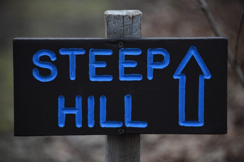 sign with arrow that says "steep hill"